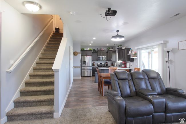 Living room with stairway, dark colored carpet, and recessed lighting | Image 6