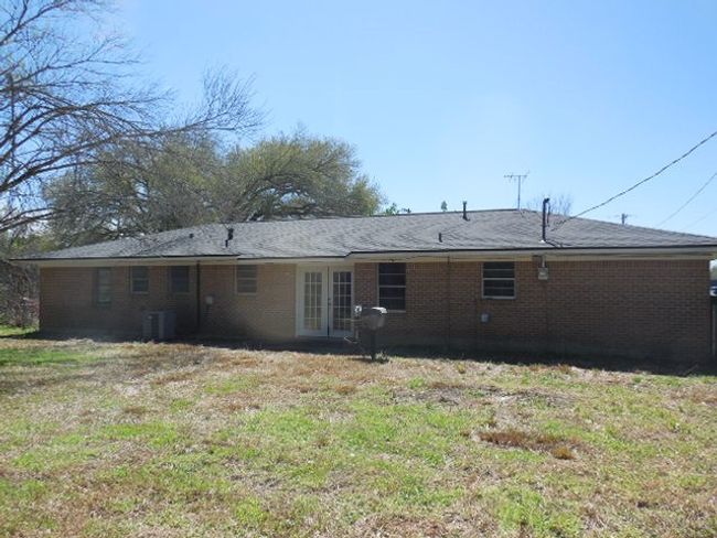 Rear view of house with central AC, french doors, and brick siding | Image 13
