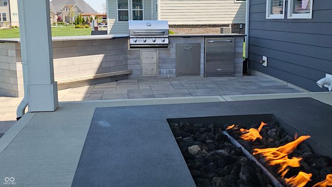 The custom grilling island is skirted with limestone steps and a beautiful paver patio! The refrigerator and grill are all included! | Image 18