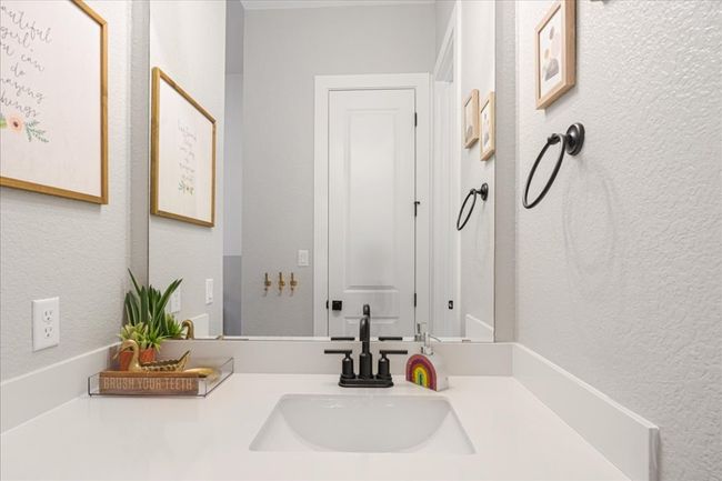 Bathroom featuring a textured wall and vanity | Image 28