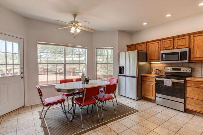 This spacious eat-in kitchen has ample cabinetry and new stainless refrigerator and range. Enjoy the views of the deck and golf course while you sip coffee! | Image 7