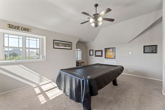 Playroom with lofted ceiling, ceiling fan, visible vents, and a healthy amount of sunlight | Image 18