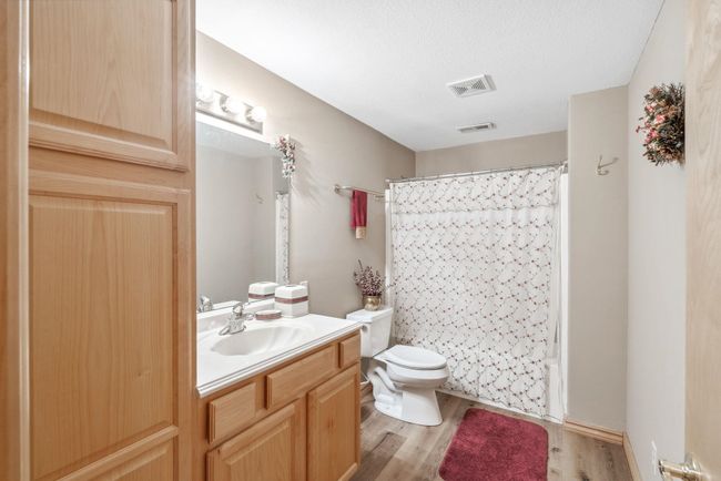 Bathroom with vanity, wood finished floors, toilet, and shower / tub combo | Image 17