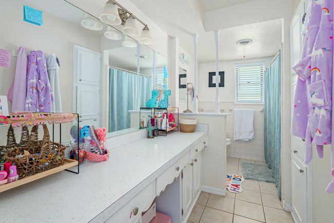 Bathroom with tile patterned flooring, vanity, toilet, and a shower with shower curtain | Image 32