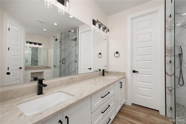Full bathroom with a marble finish shower, wood finished floors, double vanity, and recessed lighting | Image 7