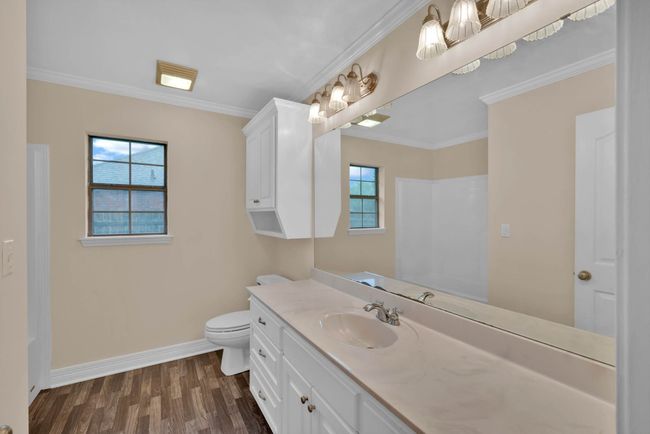 Bathroom with vanity, wood finished floors, a shower, and crown molding | Image 26