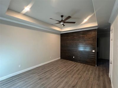 Spare room featuring a raised ceiling, dark hardwood / wood-style floors, and ceiling fan | Image 3