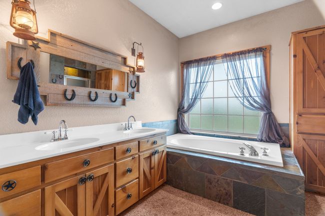 Full bathroom featuring a garden tub, double vanity, and a sink | Image 35