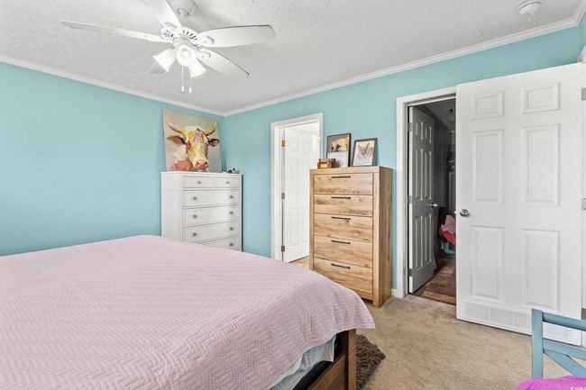 Bedroom featuring light colored carpet, ornamental molding, and ceiling fan | Image 15