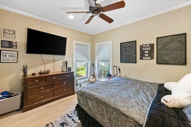 Bedroom featuring wood finished floors, ornamental molding, and ceiling fan | Image 22