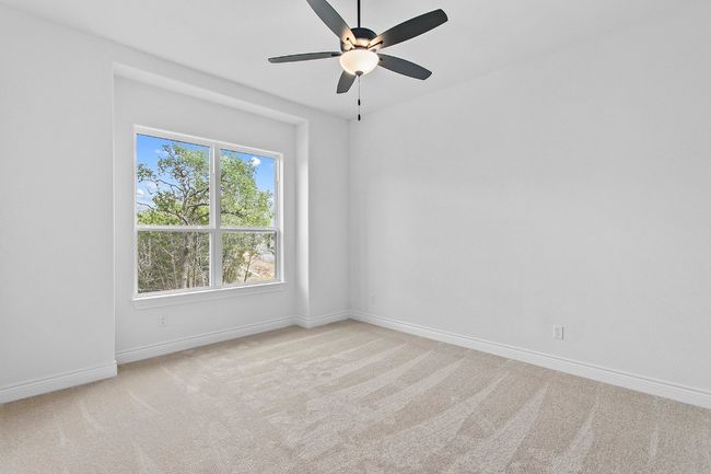 Bedroom 1- Carpeted empty room featuring a ceiling fan and baseboards | Image 22