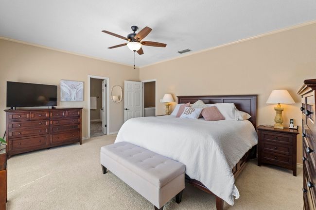 Bedroom with visible vents, baseboards, light colored carpet, and crown molding | Image 21