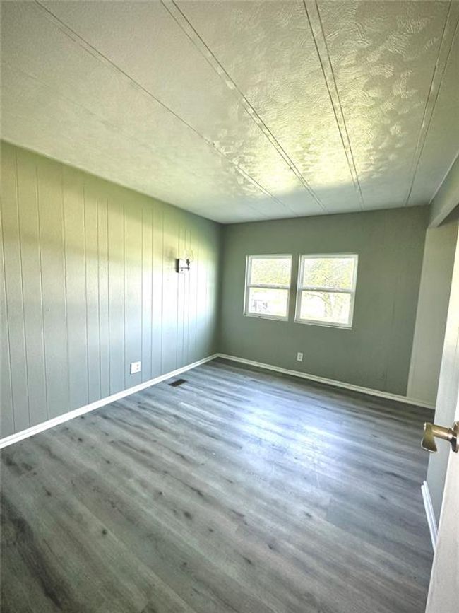 Spare room featuring wood finished floors, a textured ceiling, and baseboards | Image 13