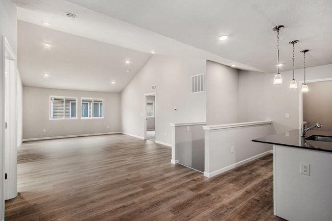 The open concept floorplan has full sight lines into the great room. There is an abundance of natural lighting from windows and is further enhanced by the vaulted ceilings and recessed lighting. | Image 8
