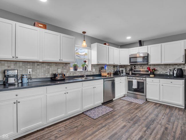 kitchen featuring dark countertops, stainless steel appliances, and a sink | Image 6
