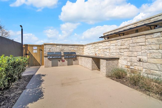 View of patio / terrace with an outdoor kitchen, a gate, a grill, and fence | Image 33