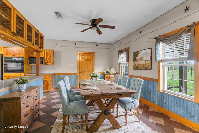 Dining space featuring ceiling fan, wainscoting, and visible vents | Image 13