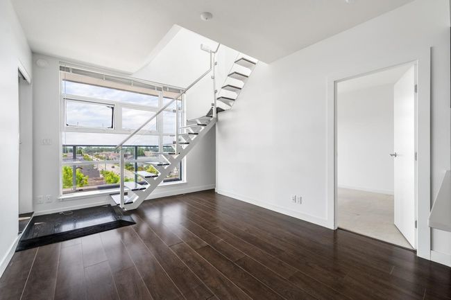 Unfurnished living room with wood finished floors and stairs | Image 4