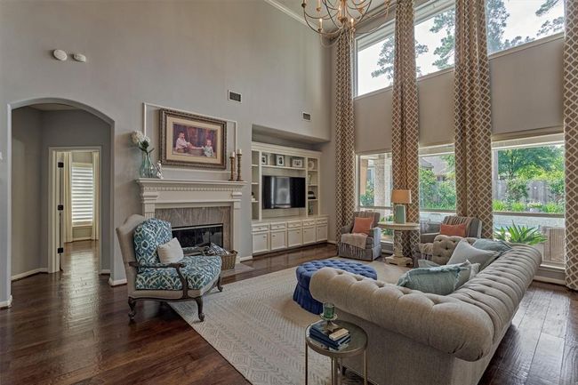 The alcove to the left leads to the Primary Suite. Large space for entertaining or cozy family time around the fireplace or watching a movie. | Image 12