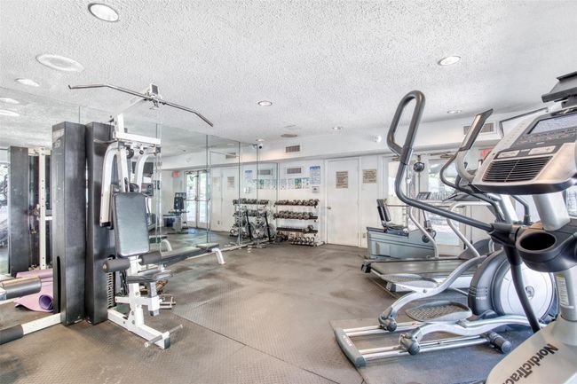 Exercise room featuring a textured ceiling | Image 30
