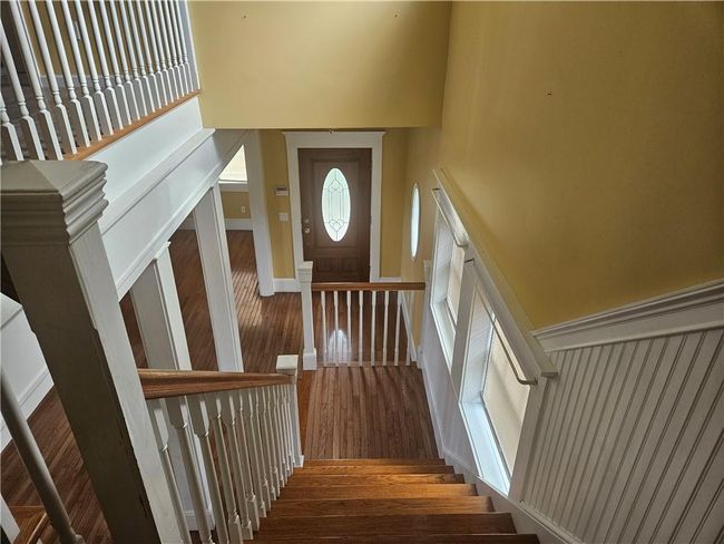 Stairway featuring wood-type flooring and a towering ceiling | Image 20