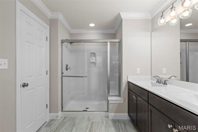 Bathroom with baseboards, ornamental molding, a shower stall, double vanity, and recessed lighting | Image 17