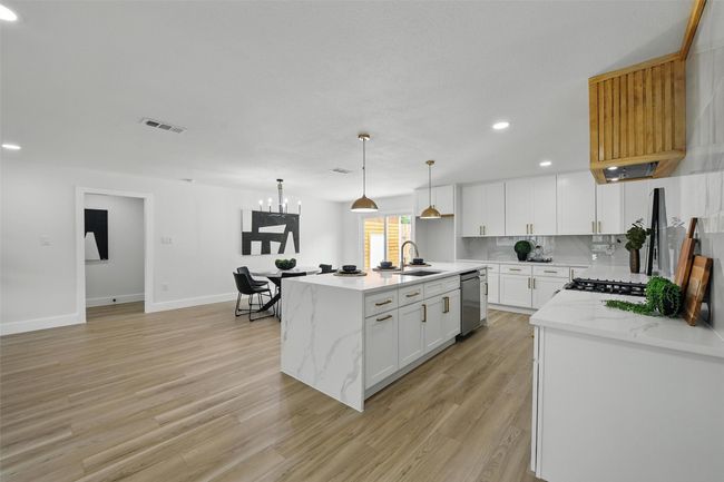 Kitchen featuring dishwasher, a sink, recessed lighting, light wood-type flooring, and baseboards | Image 11