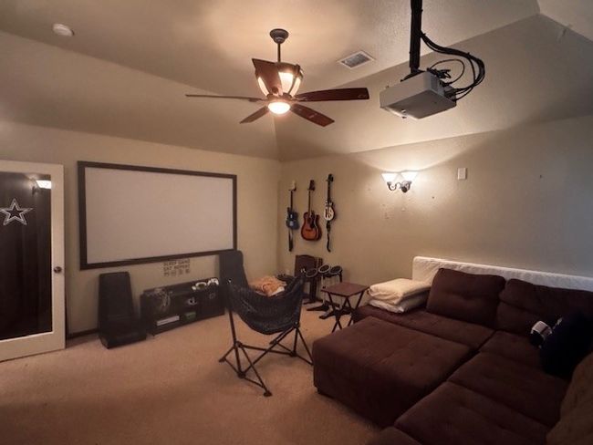 Home theater room with light colored carpet, ceiling fan, and visible vents | Image 14