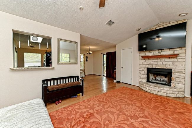Living area with lofted ceiling, a fireplace and wood finished floors | Image 5