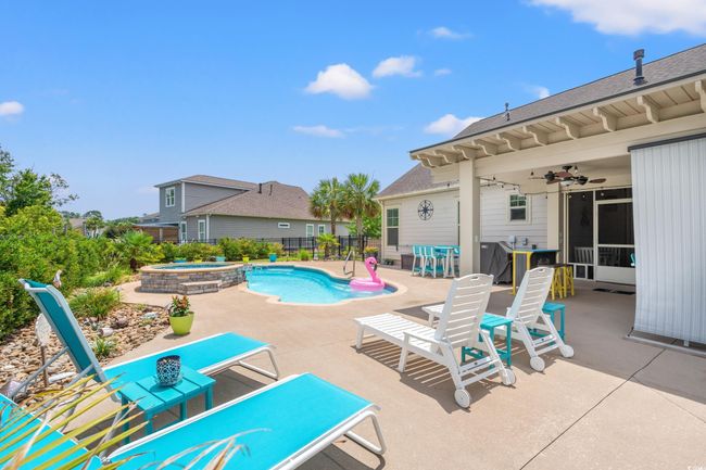 View of swimming pool featuring a patio, ceiling fan, and a pool with connected hot tub | Image 32