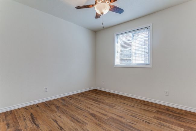 Empty room featuring ceiling fan, wood finished floors, and baseboards | Image 11