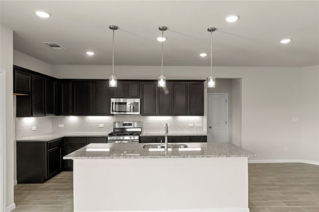 Kitchen with stainless steel appliances, wood tiled floors, light stone countertops, and recessed lighting | Image 14