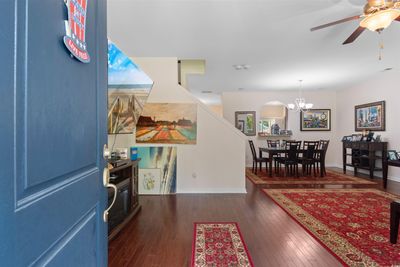 Foyer entrance featuring ceiling fan with notable chandelier and dark hardwood / wood-style flooring | Image 3