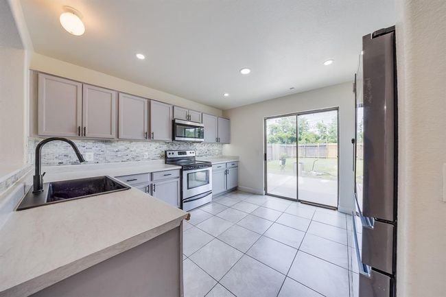 Kitchen with convenient access to the backyard, perfect for indoor-outdoor living and easy entertaining. | Image 14