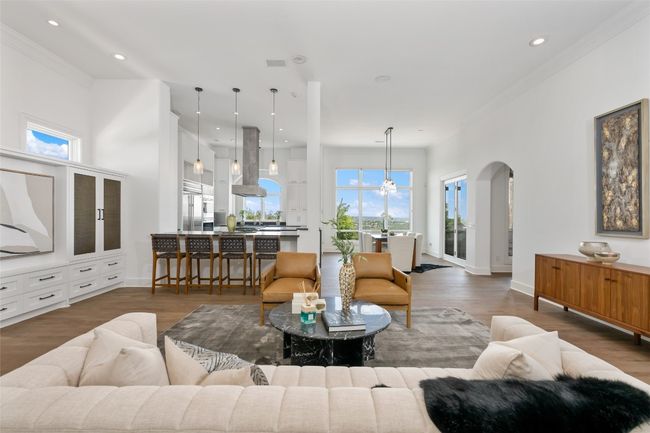 Living room with ornamental molding, arched walkways, recessed lighting, wood finished floors, and baseboards | Image 8