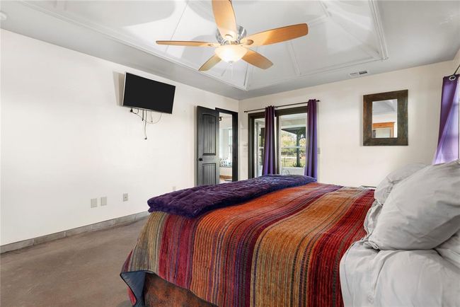 Bedroom with baseboards, visible vents, a ceiling fan, and finished concrete floors | Image 14
