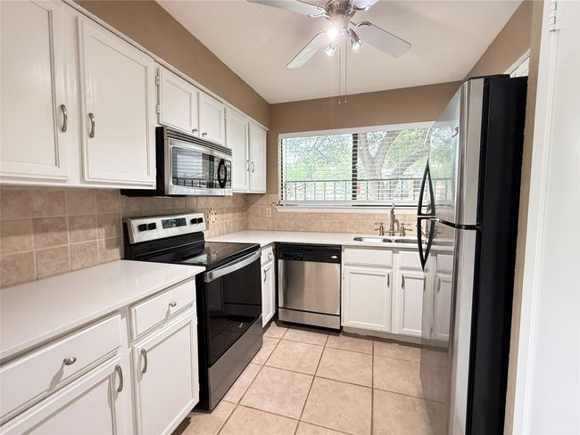 The updated kitchen with quartz counters and recent stainless appliances | Image 14
