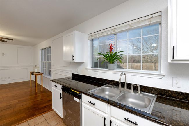 Kitchen featuring white cabinetry, granite counters, ceiling fan, a sink, and stainless steel dishwasher NEW 3/25! | Image 11