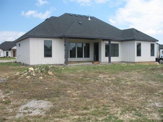 Rear view of house with roof with shingles and board and batten siding | Image 19