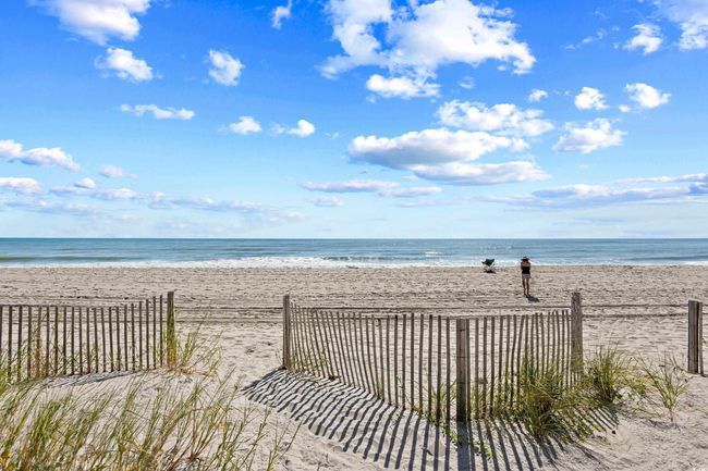 View of water feature with fence and a view of the beach | Image 35