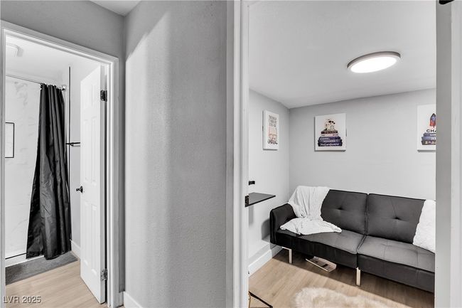 Corridor with a textured wall, wood finished floors, and baseboards | Image 34