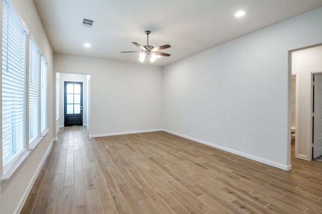 Empty room with light wood-type flooring and ceiling fan | Image 6