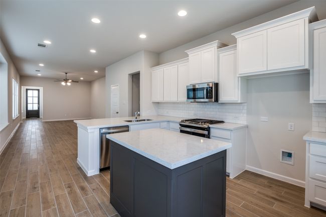 Kitchen with kitchen peninsula, stainless steel appliances, ceiling fan, sink, and light hardwood / wood-style flooring | Image 13