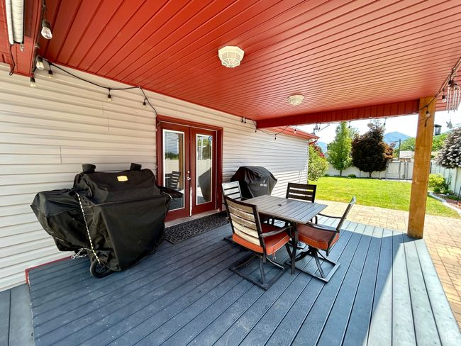 Wooden deck with french doors, outdoor dining space, and grilling area | Image 32