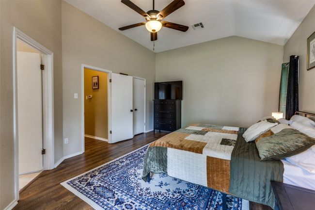 Bedroom with wood finished floors, vaulted ceiling, a ceiling fan, and baseboards | Image 13