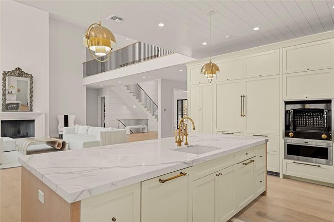 Kitchen featuring a sink, recessed lighting, open floor plan, light wood-style floors, and light stone counters | Image 29