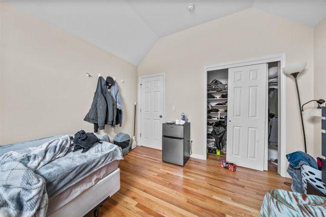 Bedroom with baseboards, light wood-type flooring, vaulted ceiling, and freestanding refrigerator | Image 32
