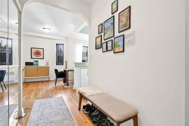 Hallway featuring arched walkways, light wood-style floors, and radiator | Image 21