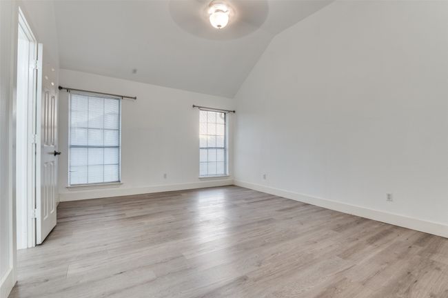 Spare room featuring ceiling fan, lofted ceiling, and light wood-type flooring | Image 15