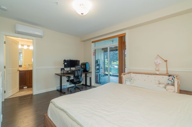 Bedroom featuring a wall unit AC, access to exterior, dark wood-type flooring, and a desk | Image 20